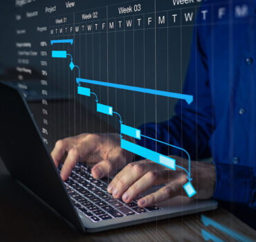 Project manager working on Gantt chart to update the schedule, tasks and milestones progress for the team. Management diagram on computer screen with person coordinating teamwork.